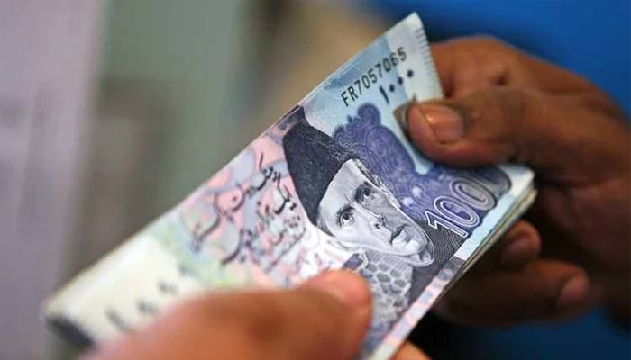 Photo showing a person holding a stack of thousand-rupee notes. — AFP/File