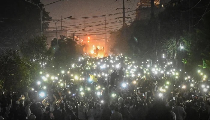 Supporters of proscribed TLP use mobile phone flashlights during a protest march towards capital Islamabad from Lahore on October 22, 2021. Photo: AFP