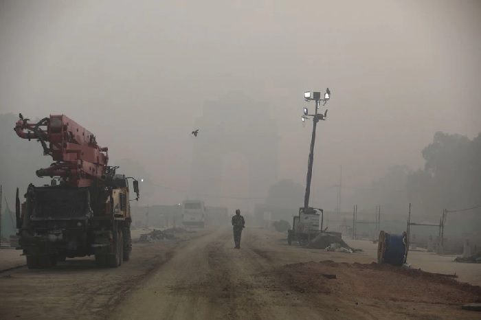 Seorang tentara paramiliter India berjalan di dekat Gerbang India yang diselimuti kabut asap, di New Delhi, India, 5 November 2021. Foto: Reuters