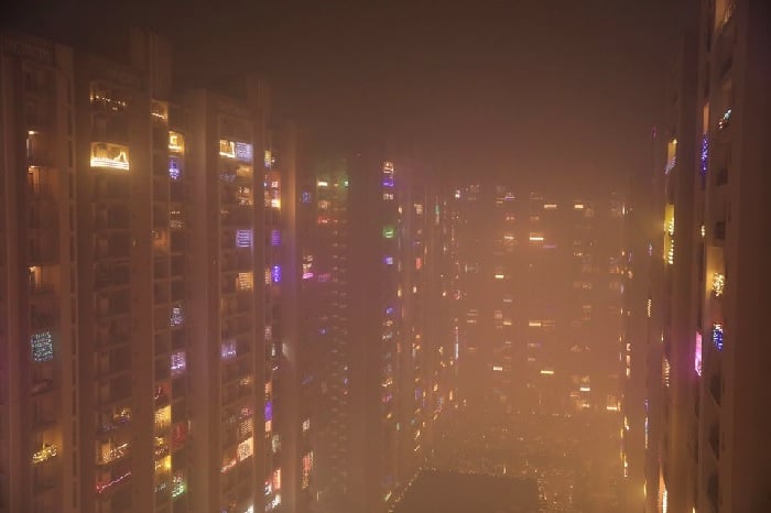 Lampu yang menghiasi balkon gedung tinggi terlihat diselimuti kabut asap di Noida, India, 5 November 2021. Foto: Reuters