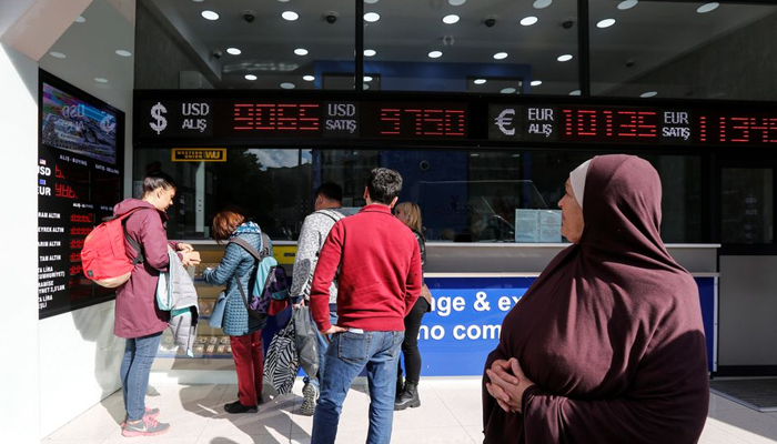 Orang-orang membeli dan menjual uang di kantor penukaran mata uang, di Istanbul, Turki 25 Oktober 2021. — Reuters/File