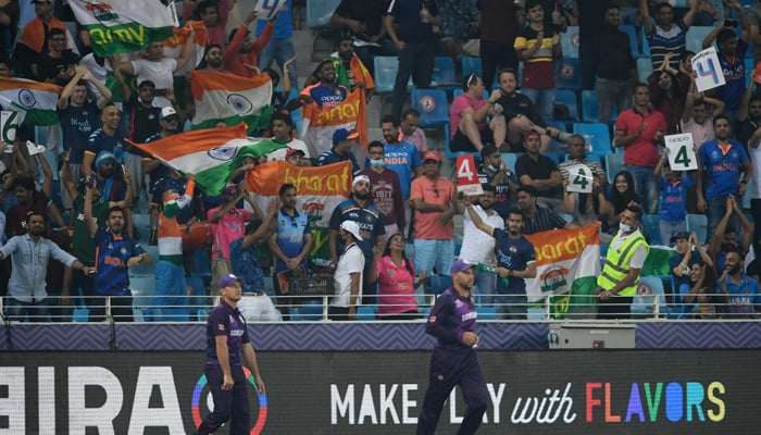 Cricket fans wave Indian flags as they cheer during the ICC Twenty20 World Cup cricket match between India and Scotland at the Dubai International Cricket Stadium in Dubai on November 5, 2021. — AFP