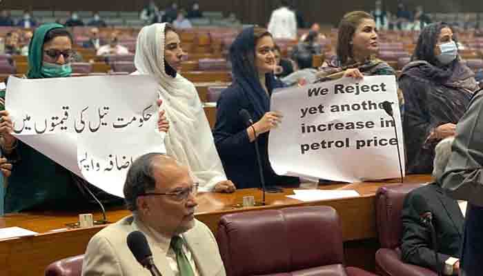 PML-N MNA’s hold placard against increasing petroleum prices during National Assembly session. -INP