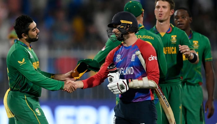 England´s Mark Wood (C) shakes hands with South Africa´s Tabraiz Shamsi at the end of the ICC Twenty20 World Cup cricket match between England and South Africa at the Sharjah Cricket Stadium in Sharjah on November 6, 2021. — AFP