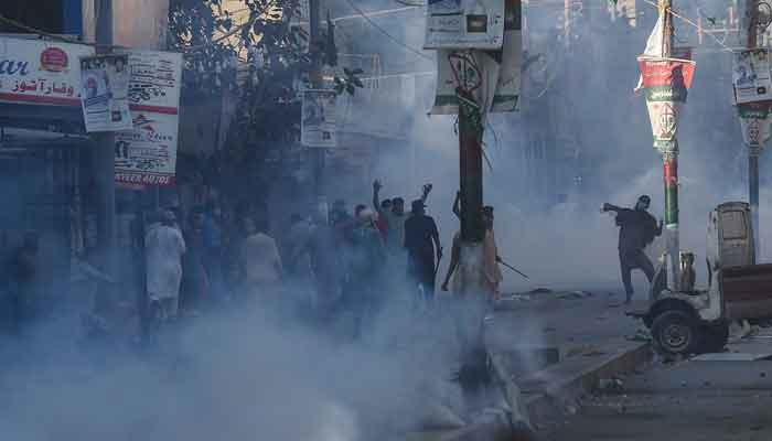 Police personnel use teargas shell to disperse supporters of a political party TLP during a protest in Karachi on April 13, 2021. — AFP/File