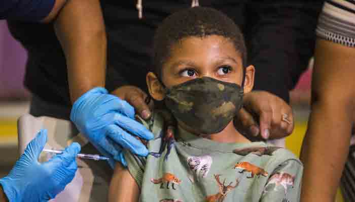 Christopher Reyes, 9, duduk diam saat dia diberikan vaksin virus corona (COVID-19) di situs sembul vaksinasi di PS 19 pada 08 November 2021 di Lower East Side di New York City.  -AFP