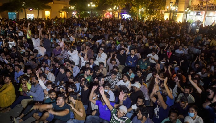 Cricket fans watch the live telecast of T20 cricket World Cup match between Pakistan and India on a television in Karachi, on October 24, 2021. — AFP/File