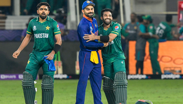 Kapten India Virat Kohli (tengah) mengucapkan selamat kepada rekannya dari Pakistan Babar Azam (kiri) dan Mohammad Rizwan setelah kemenangan mereka selama pertandingan kriket Piala Dunia ICC Twenty20 antara India dan Pakistan di Stadion Kriket Internasional Dubai di Dubai pada 24 Oktober 2021. — AFP /Mengajukan