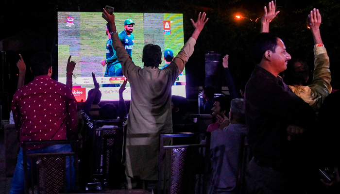 Cricket fans watch the live telecast of T20 cricket World Cup match between India and Pakistan happening in Dubai on a big screen in Lahore on October 24, 2021. — AFP/File