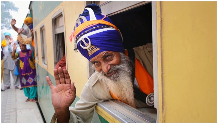 Peziarah Sikh melambaikan tangan saat tiba di Stasiun Kereta Api Wagah.  - ON LINE