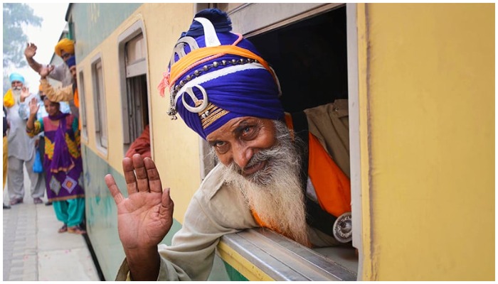 Peziarah Sikh melambaikan tangan saat tiba di Stasiun Kereta Api Wagah. - ON LINE