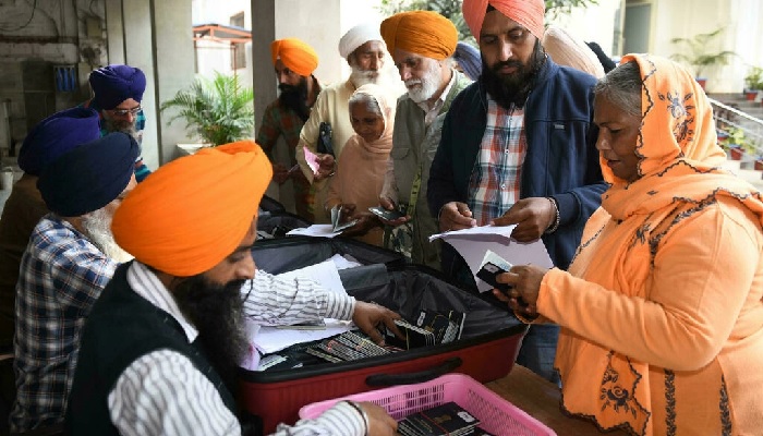 Peziarah Sikh mengumpulkan paspor mereka pada malam perjalanan ke Pakistan untuk merayakan ulang tahun kelahiran Guru Nanak.  foto: AFP
