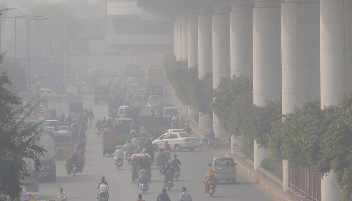 Orang-orang bepergian di sepanjang jalan di tengah kondisi kabut asap tebal di Lahore pada 18 November 2021. — Online