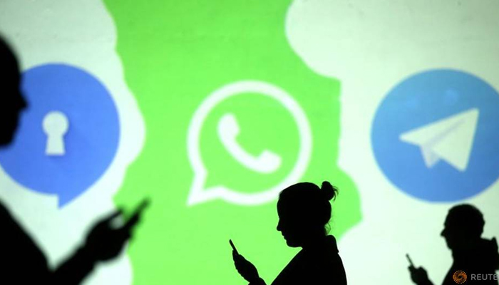 Siluet pengguna ponsel terlihat di sebelah logo aplikasi media sosial Signal, Whatsapp, dan Telegram yang diproyeksikan di layar dalam ilustrasi gambar yang diambil 28 Maret 2018. — Reuters/File