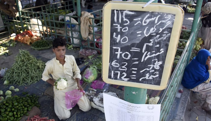 Daftar harga sayuran ditampilkan di bazaar Minggu di Aabpara di Islamabad.  — Daring/Berkas