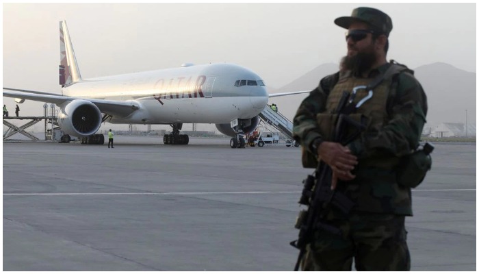 A member of Taliban security forces stands guard in front of a Qatar Airways airplane boarding passengers at the international airport in Kabul, Afghanistan, September 10, 2021. WANA (West Asia News Agency) via REUTERS/File Photo