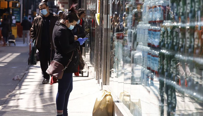 A woman texts on her mobile phone as she waits for a friend outside a supermarket on Roosevelt Avenue during the outbreak of the coronavirus disease (COVID-19) in the Queens borough of New York City, New York, US, April 2, 2020. — Reuters/File