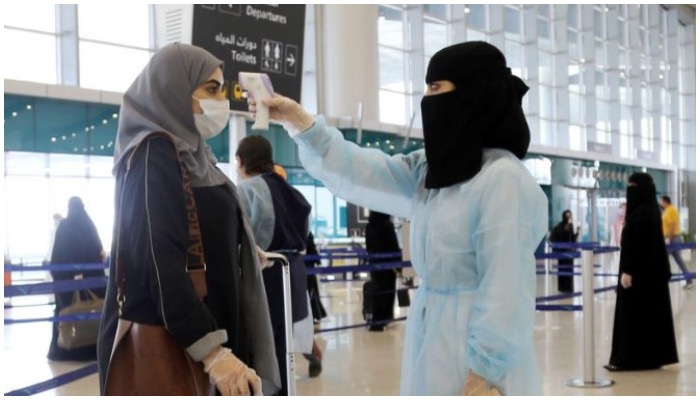 A security woman checks the temperature of a woman at Riyadh International Airport, after Saudi Arabia reopened domestic flights, following the outbreak of the coronavirus disease (COVID-19), in Riyadh, Saudi Arabia May 31, 2020. REUTERS/Ahmed Yosri