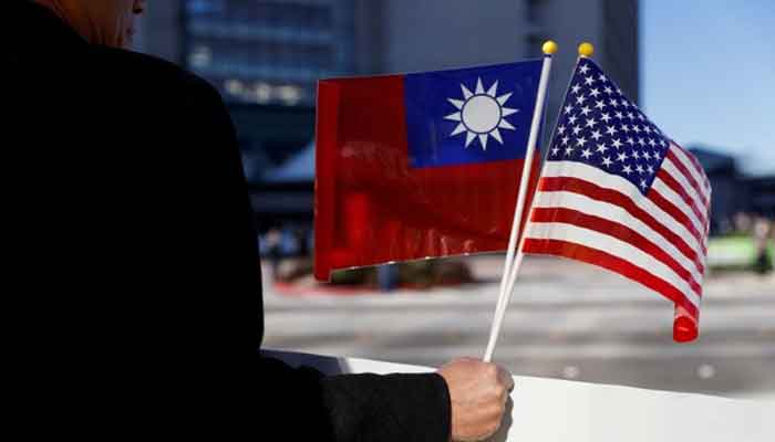 A lawmaker holds Taiwan, USA flag. Photo: Twitter