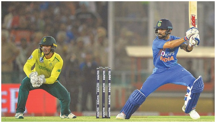 Indian skipper Virat Kohli plays a shot as his South African counterpart Quinton de Kock looks on during the second T20 International at the PCA Stadium.—AFP/File