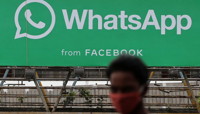 A man walks past a hoarding of the WhatsApp application installed at a skywalk in Mumbai, India, August 26, 2021. — Reuters/File