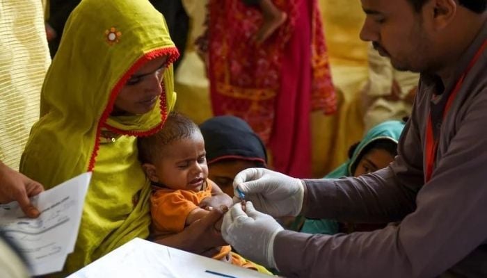 A paramedic takes a babys blood for an HIV test in Larkana, Pakistan - Photo: Afp