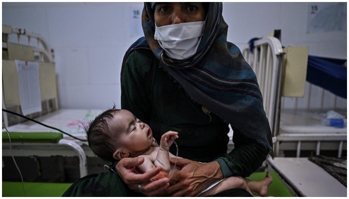 This picture taken on Nov 22, 2021 shows Edi Maa holding her baby receiving treatment for malnutrition at a Doctors Without Borders (MSF) nutrition centre in Herat. — AFP