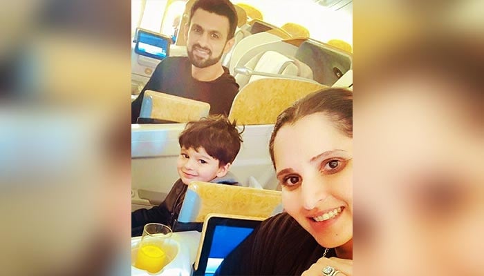 Pakistan cricketer Shoaib Malik pose with wife, Sania Mirza, and son during their flight to Dubai. — Instagram