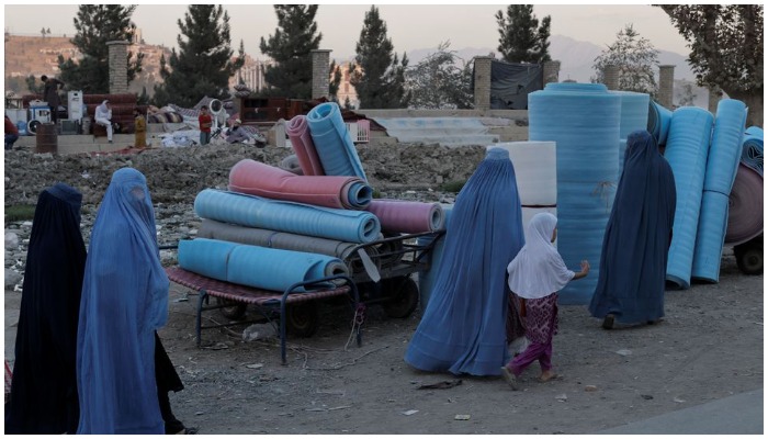 Women wearing burqas walk in a second-hand market where people sell their home appliances and other belongings, in Kabul, Afghanistan October 9, 2021. Photo: Reuters