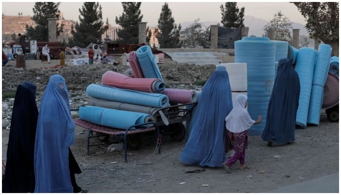 Women wearing burqas walk in a second-hand market where people sell their home appliances and other belongings, in Kabul, Afghanistan October 9, 2021. Photo: Reuters