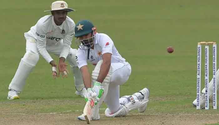 Pakistan captain Babar Azam bends for a lap sweep. Photo: AFP