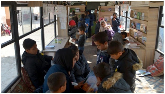 Children inside a mobile library which opened its doors for the first time since the Taliban’s return to power, in Kabul on December 5, 2021. Photo: AFP