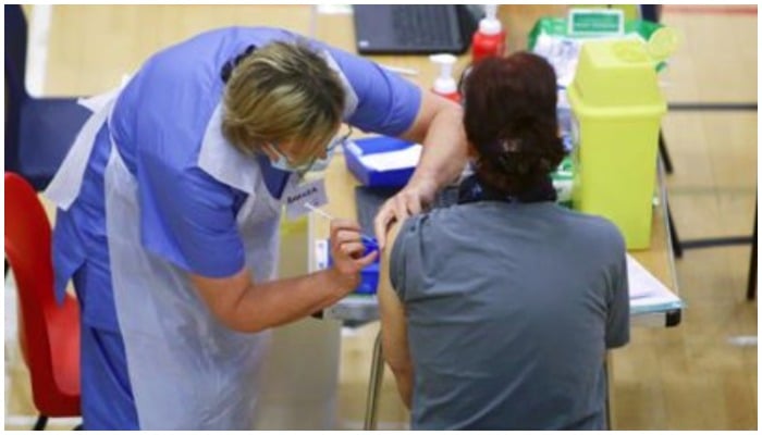 A woman receives an Oxford-AstraZeneca coronavirus disease (COVID-19) vaccine at a COVID-19 vaccination centre at Cwmbran Stadium in Cwmbran, South Wales, Britain February 17, 2021. Geoff Caddick/Pool via Reuters