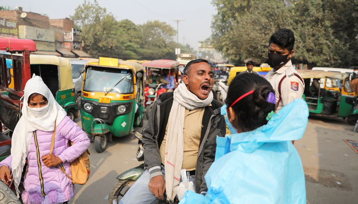 A healthcare worker collects a coronavirus disease (COVID-19) test swab sample from a man on a road in New Delhi, India, December 6, 2021. — Reuters