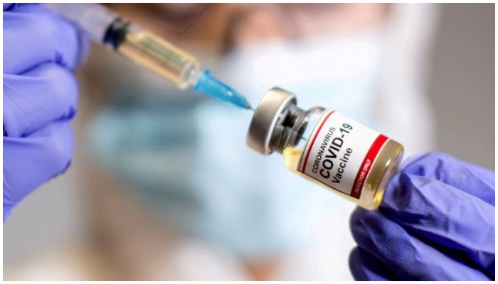 A woman holds a small bottle labelled with a Coronavirus COVID-19 Vaccine sticker and a medical syringe in this illustration taken October 30, 2020. — Reuters/Dado Ruvic/File Photo