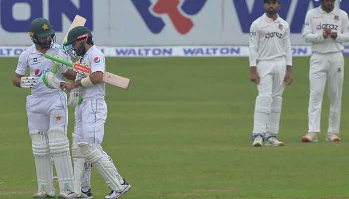 Pakistani batsmen Fawad Alam and Mohammad Rizwan confer during a review. Photo: AFP