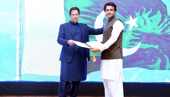 Prime Minister Imran Khan awards a commendatory certificate to Malik Adnan — the person who tried to save the late Priyantha Kumara Diyawadana during Sialkot Incident — at the PM Office in Islamabad on December 7, 2021. — PID