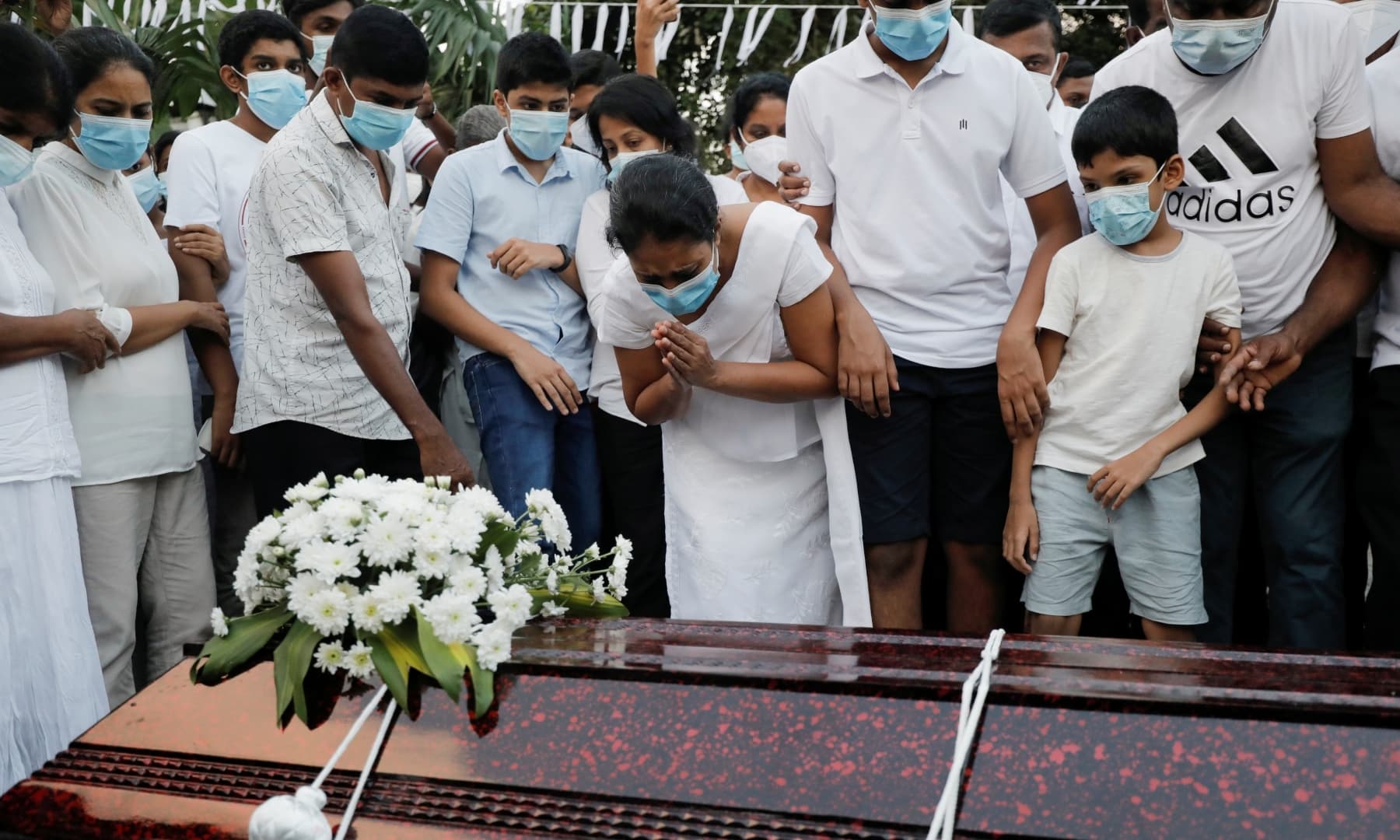 Wife and sons of Priyantha Kumara gathered around coffin. Photo: Reuters