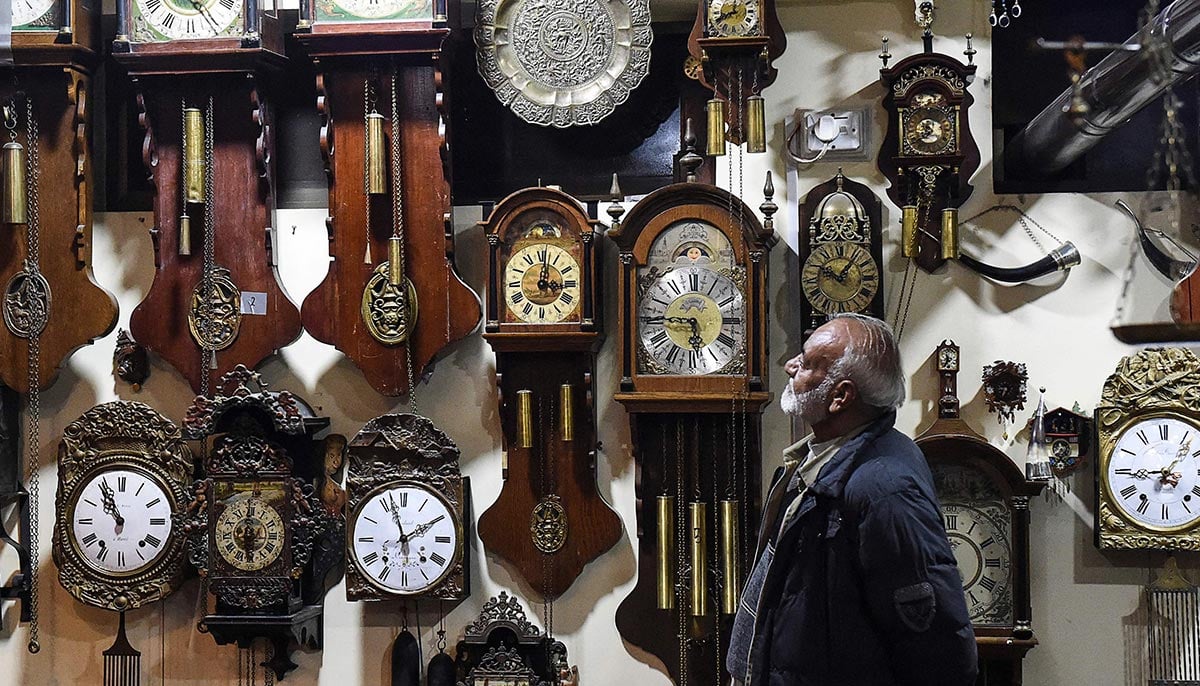 In this picture taken on November 26, 2021, a visitor looks at antique clocks collection at a museum housed inside the citys tribal police headquarters compound in Quetta. — AFP
