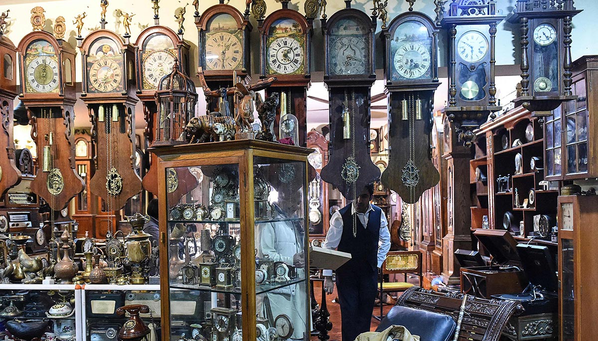 In this picture taken on November 26, 2021, collector Gul Kakar walks around his antique clocks at a museum housed inside the citys tribal police headquarters compound in Quetta. — AFP