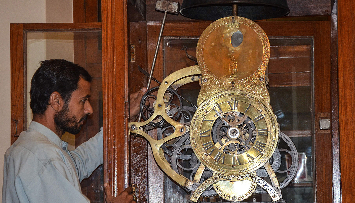 In this picture taken on November 30, 2021, an employee maintains an antique clock, handmade in 1847 by East India Company colonial administrator John Jacob, in a government building in Jacobabad, Sindh province. The tick-tock of hundreds of antique clocks fills a small hall in the southwestern Pakistani city of Quetta, where collector Gul Kakar, a 44-year-old police officer, swears he will spend all the time he has left caring for them. — AFP