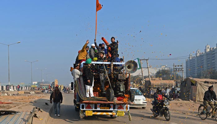 Farmers cheer as they leave the protesting site at the Delhi-Haryana state border in Singhu on December 11, 2021, as Indian farmers formally ended year-long mass protests after Prime Minister Narendra Modi abandoned his push for agricultural reforms.&mdash; AFP