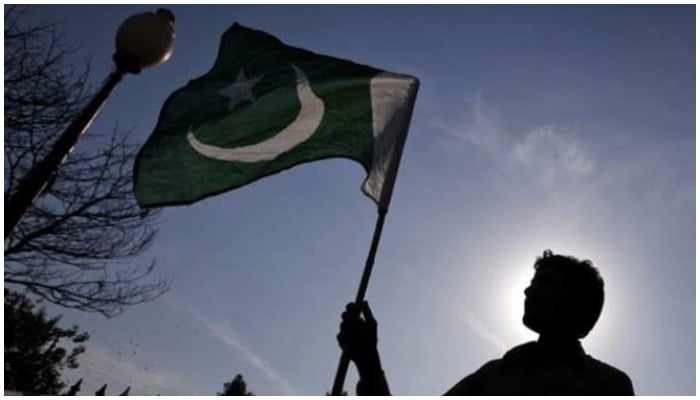 A man holds a flag of Pakistan. Photo: Reuters