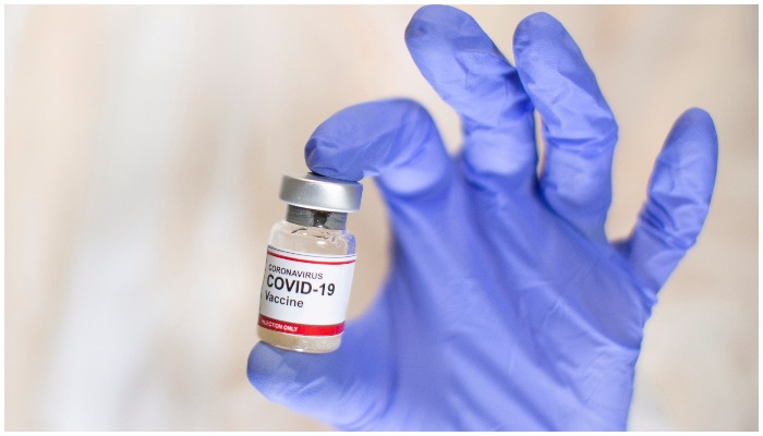 A woman holds a small bottle labelled with a Coronavirus COVID-19 Vaccine sticker in this illustration taken, October 30, 2020. Photo: Reuters