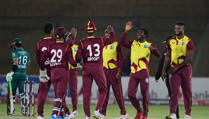 West Indies cricketers celebrate the wicket of Pakistan cricket captain Babar Azam (not pictured) during the second T20 international cricket match between Pakistan and West Indies at the National Stadium in Karachi on December 14, 2021. — AFP