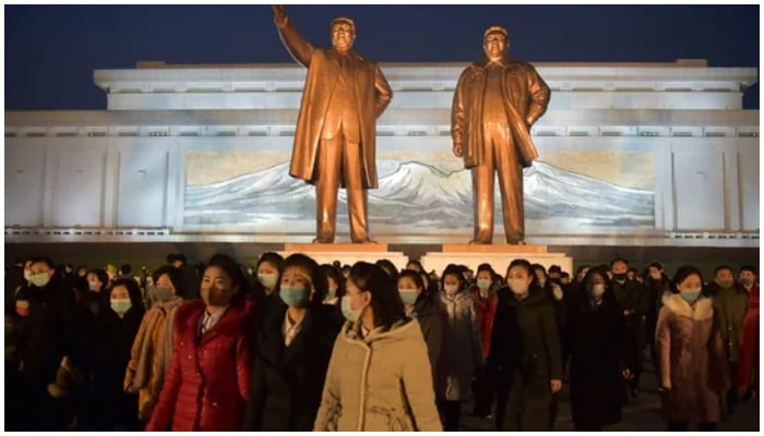 People come to pay their respects before the statues of late North Korean leaders Kim Il Sung and Kim Jong il to mark the 10th death anniversary of Kim Jong uns father, Kim Jong il.(AFP)