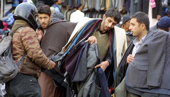 People purchase warm clothes at a roadside stall amid winter season in Pakistan. Photo: APP