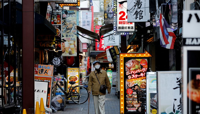 A man wearing a protective mask, amid the coronavirus disease (COVID-19) outbreak, makes his way at a restaurant district in Tokyo, Japan, December 1, 2021. — Reuters