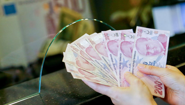 A money changer holds Turkish lira banknotes at a currency exchange office in Ankara, Turkey September 27, 2021.— Reuters/File
