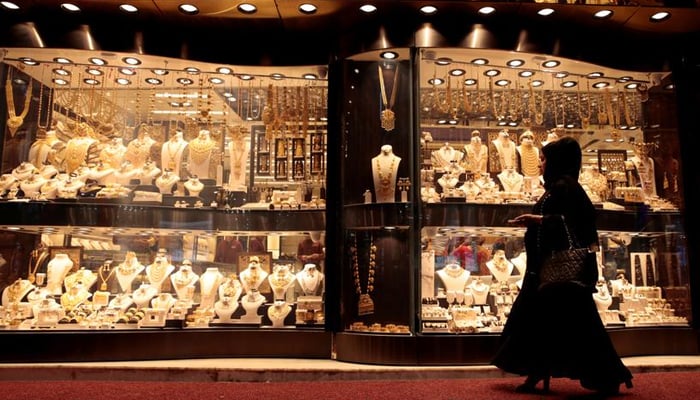 A woman walks past gold jewellery displayed in a shop window at the Gold Souq in Dubai, United Arab Emirates March 24, 2018. — Reuters/File